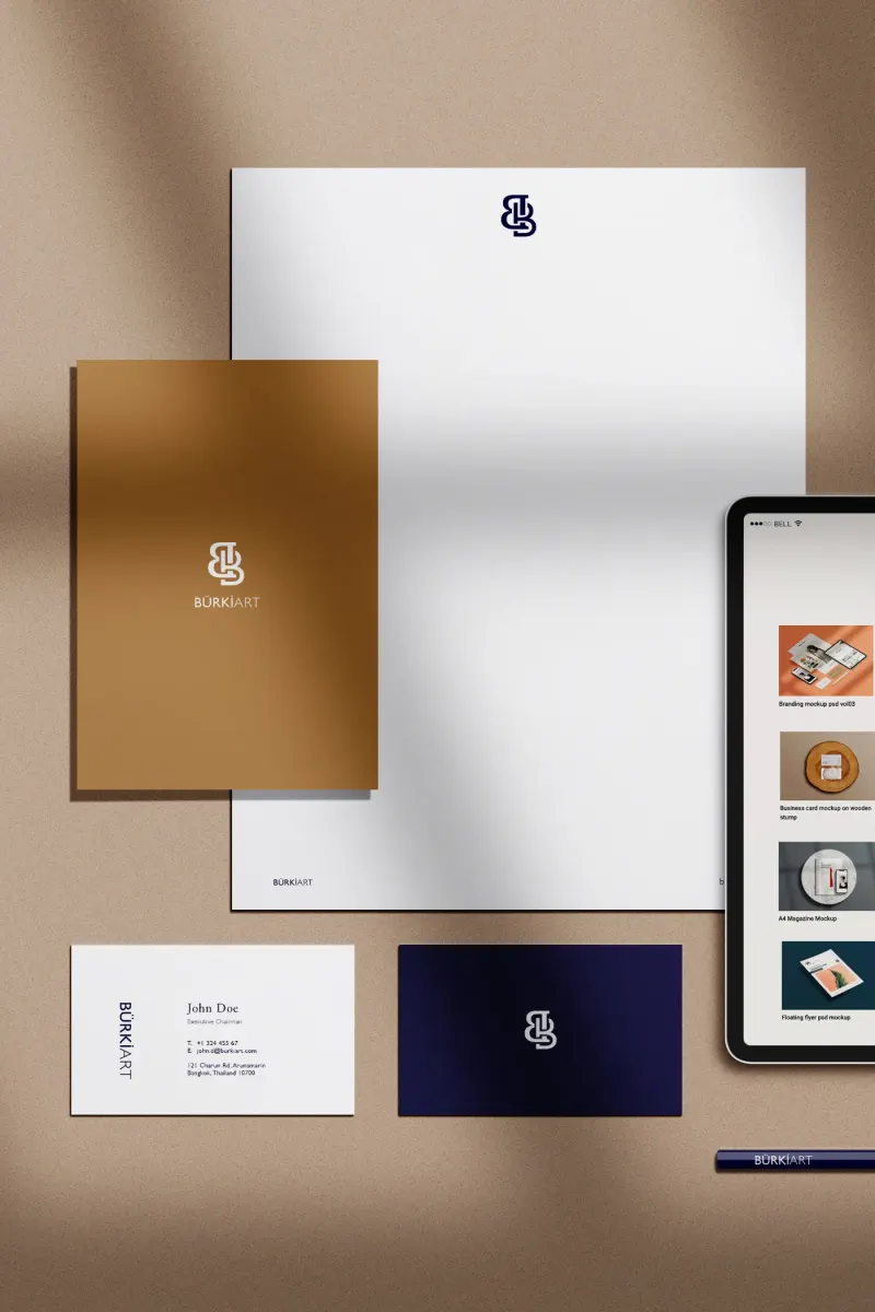 Geschäftsausstattung in Braun und Gold: Briefpapier, Mappe, Visitenkarten und Tablet mit Website